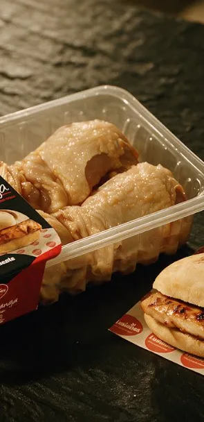 AI-generated product advertising image: packaged chicken and a grilled chicken sandwich